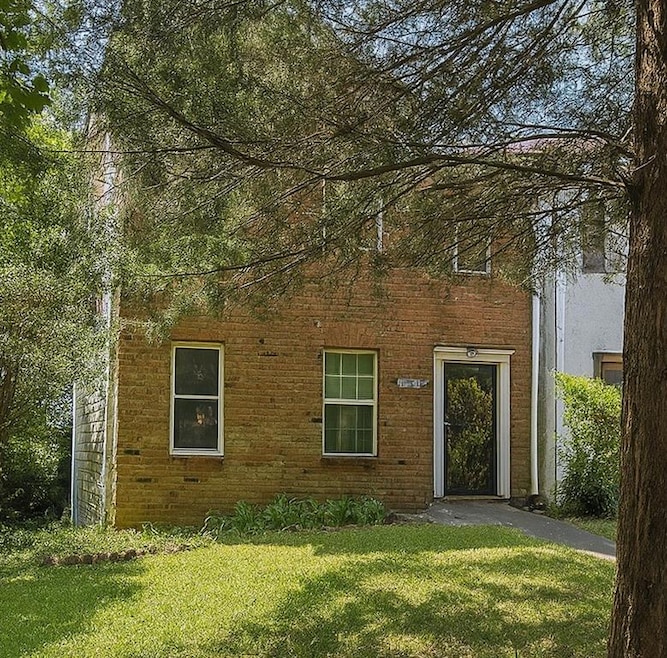 View of front of house with a front lawn and brick siding