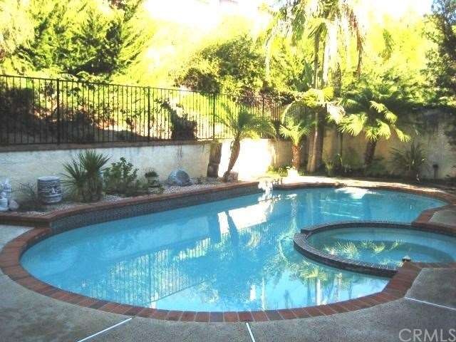 View of pool looking onto burm.  Very lush yard.