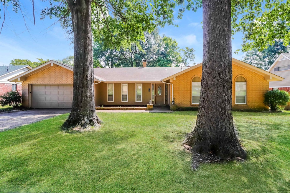 Single story home featuring a front yard, brick siding, asphalt driveway, and a garage