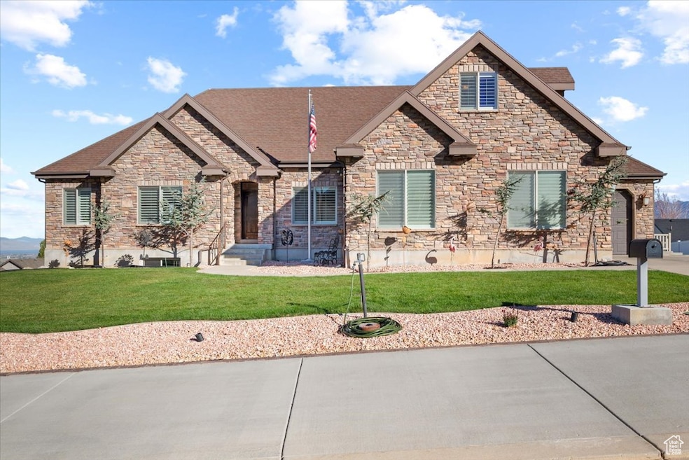 Craftsman-style house featuring a front lawn, stone siding, and a shingled roof