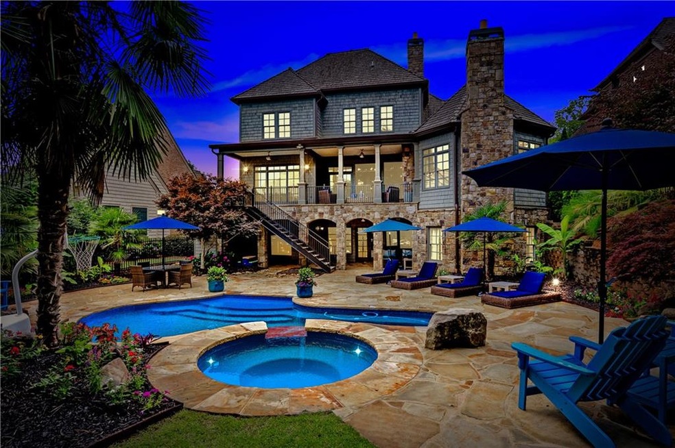 Night view of pool, patio and home..stone arched d