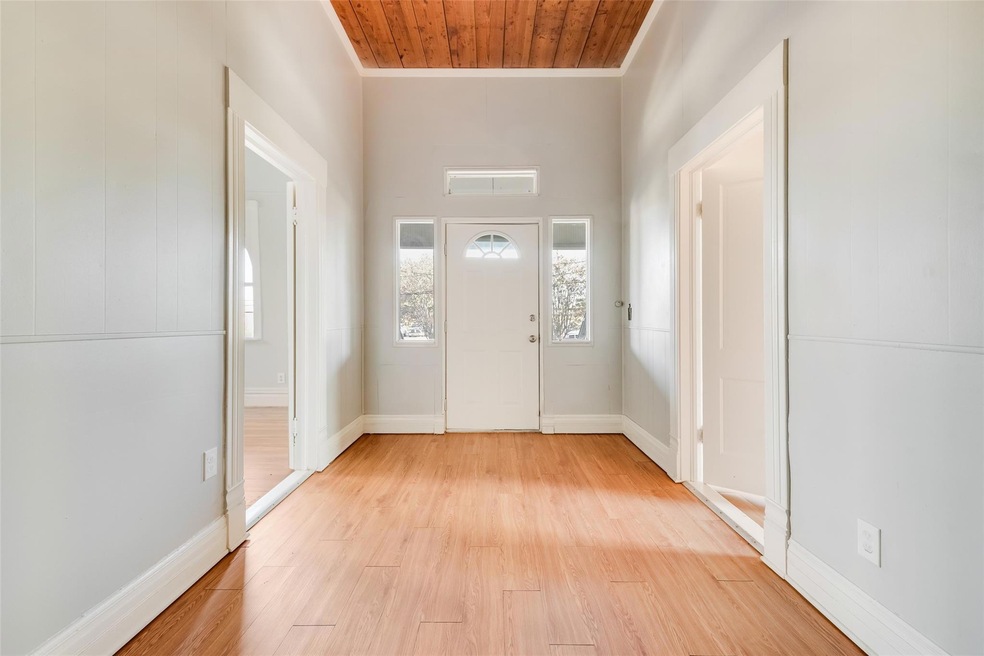 Entrance foyer featuring wood ceiling, ornamental molding, and light hardwood / wood-style flooring