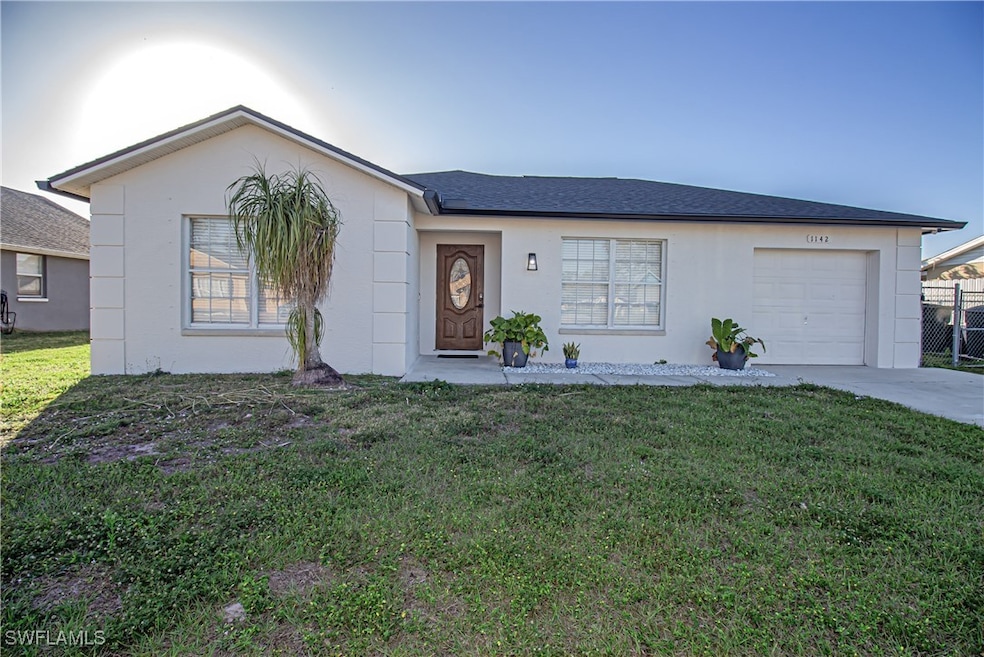 Ranch-style home with a garage and a front lawn