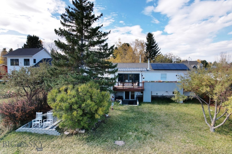 Rear view of property with solar panels, a deck, a