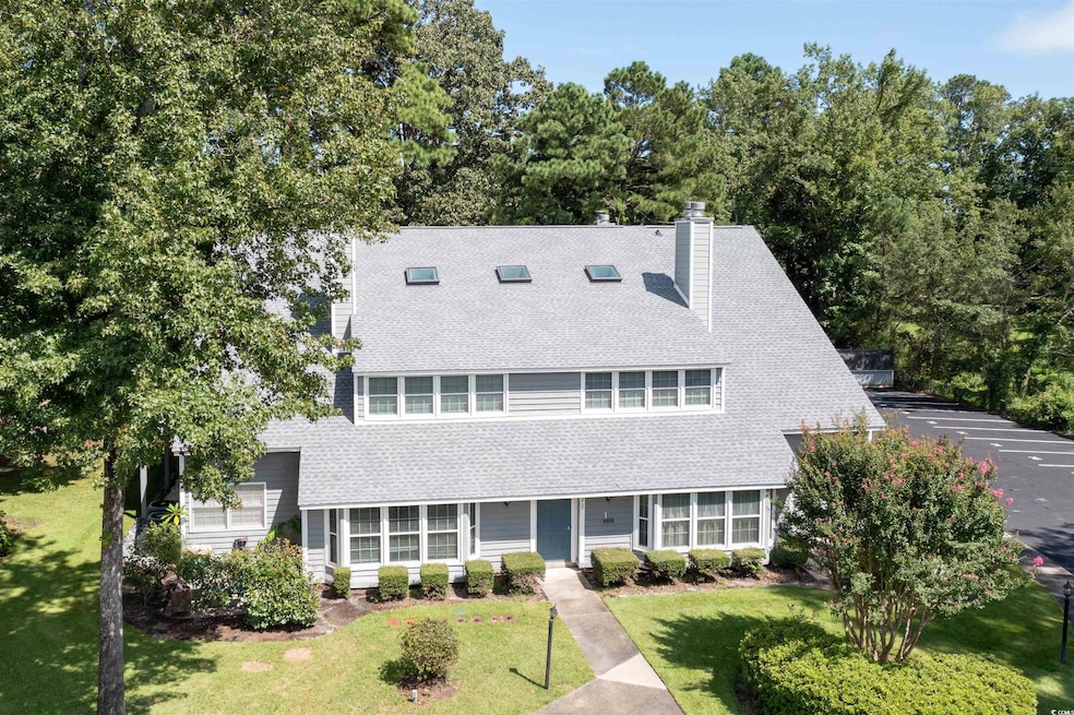 View of front facade featuring a shingled roof, a front lawn, and a chimney