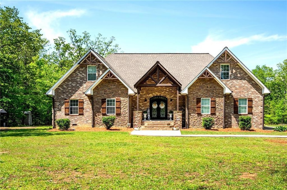 Craftsman-style house with a front lawn, roof with shingles, and brick siding
