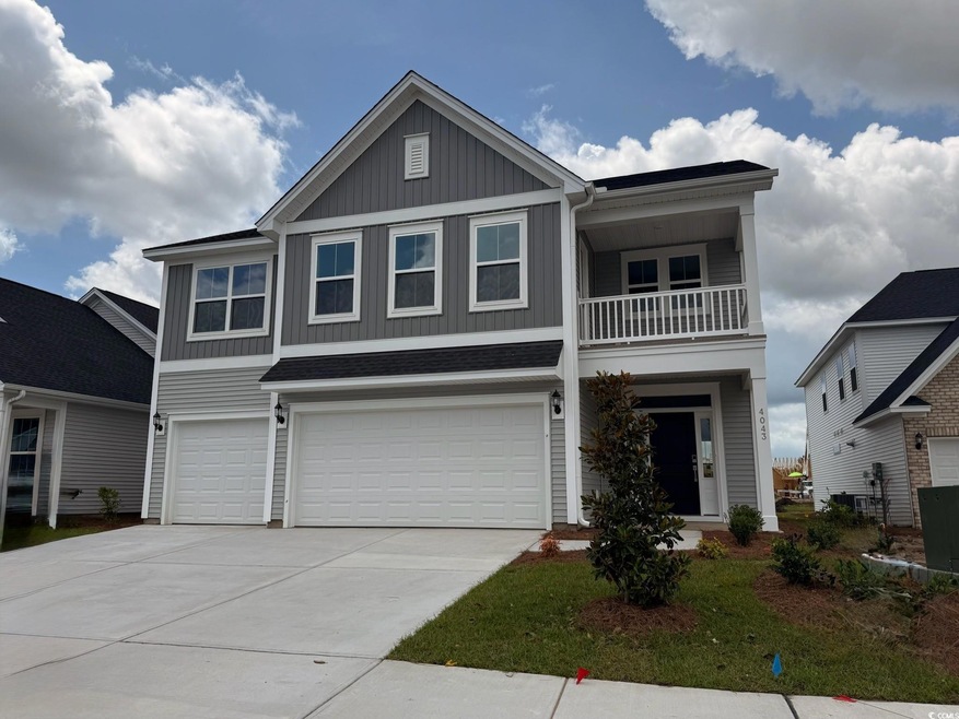 View of front facade featuring board and batten siding, an attached garage, a balcony, and driveway