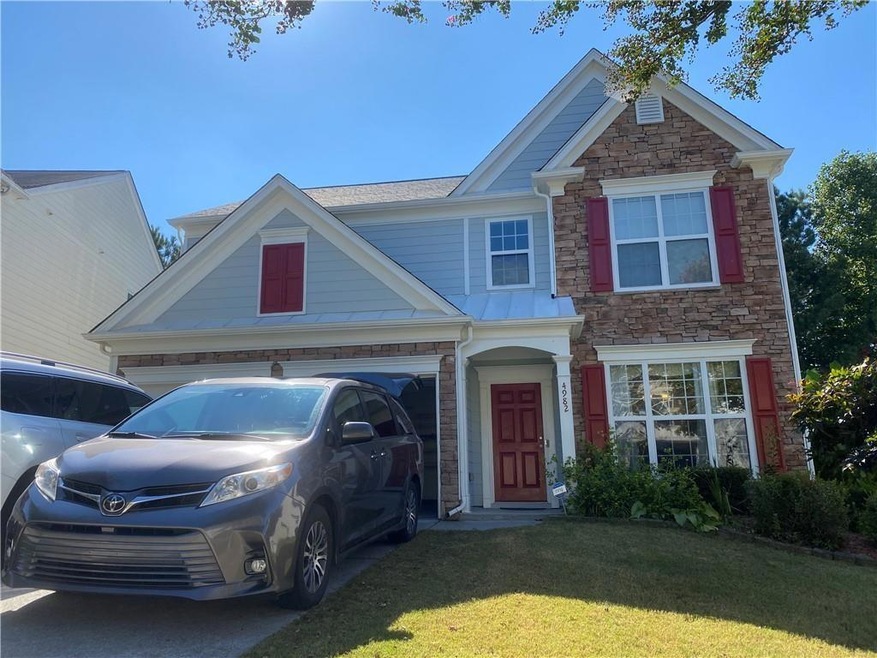 View of front of house with a front yard and a gar