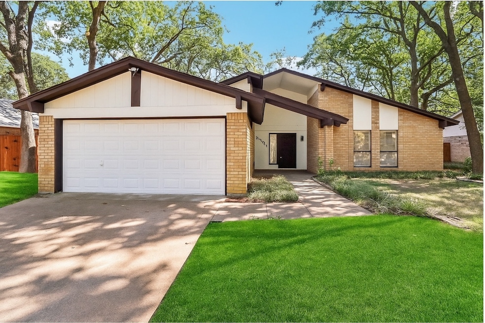 Mid-century modern home featuring brick siding, a front lawn, concrete driveway, and an attached garage