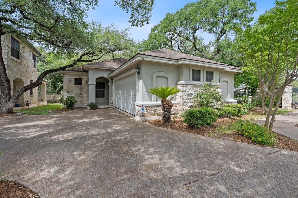 View of front of house with stucco siding, stone 
