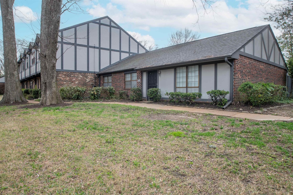 Tudor house featuring brick siding, a shingled roo
