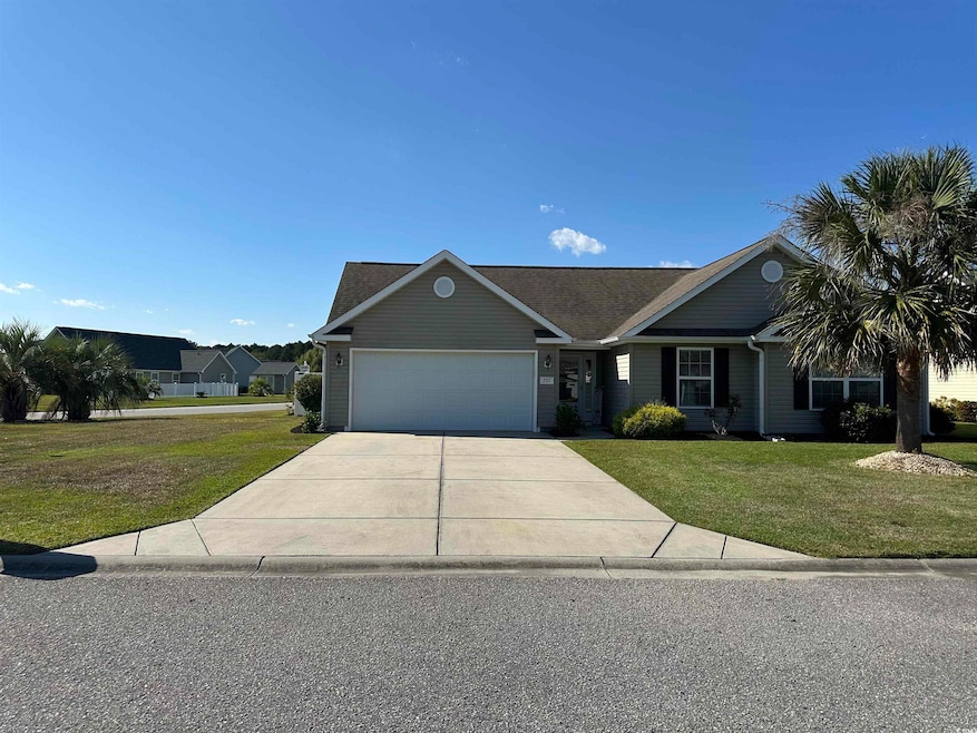 Ranch-style home featuring a front lawn, concrete driveway, and an attached garage