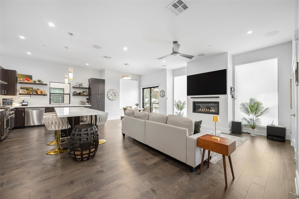 Living room featuring ceiling fan, dark hardwood /