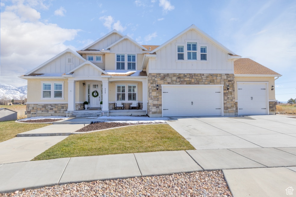 Craftsman house with stone siding, board and batten siding, and concrete driveway