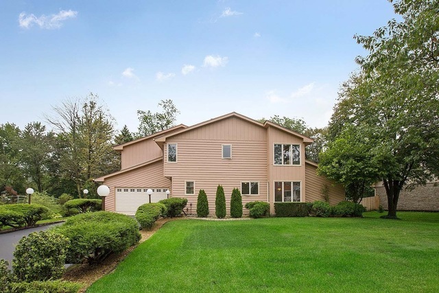 Features a wooded lot, spacious driveway, and 2.5 
