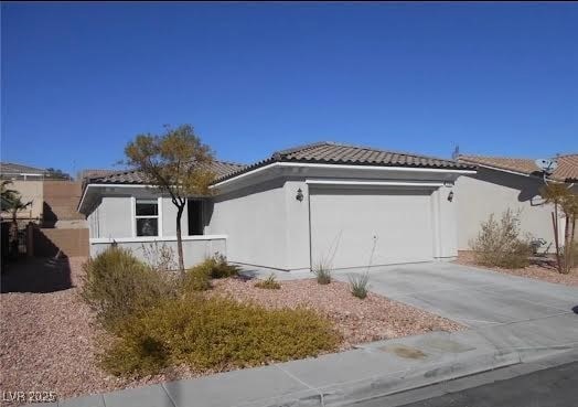 View of side of property with driveway, a garage, stucco siding, and a tile roof