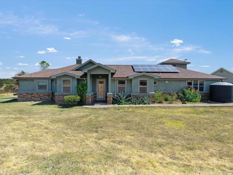 View of front of home with solar panels, a front 