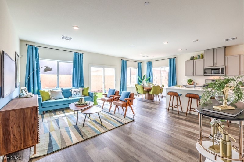 Living room with light wood finished floors and recessed lighting. Photo is representational only; actual home finishes may vary.
