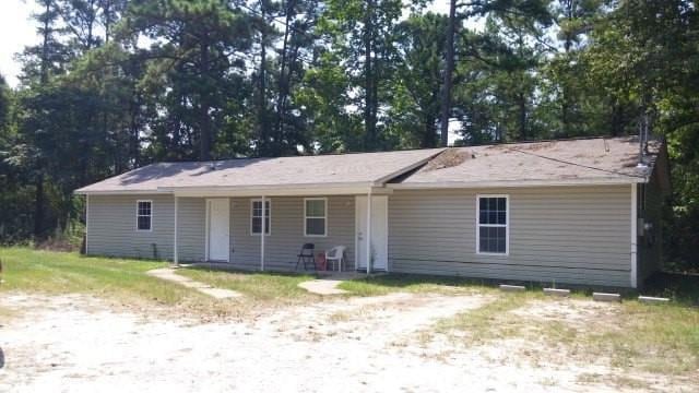 View of front of home with covered porch and view of scattered trees