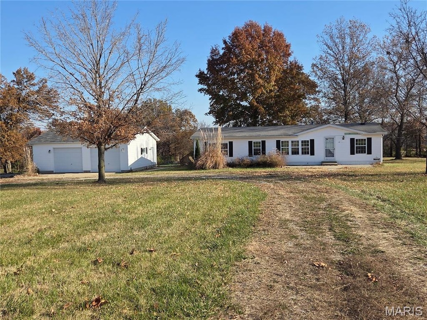 Ranch-style house with a front lawn, an outbuilding, and a garage