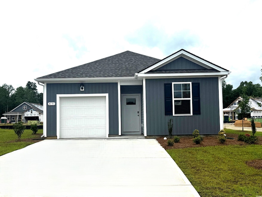 View of front of house with a front yard, an attached garage, concrete driveway, and roof with shingles