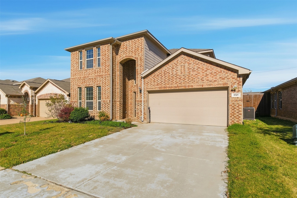 Traditional-style home featuring concrete driveway, an attached garage, and brick siding