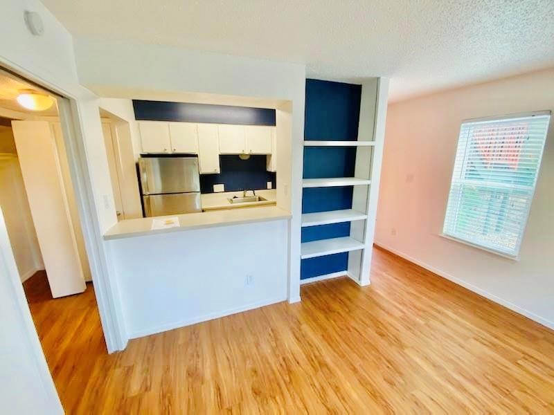 Kitchen with freestanding refrigerator, light woo