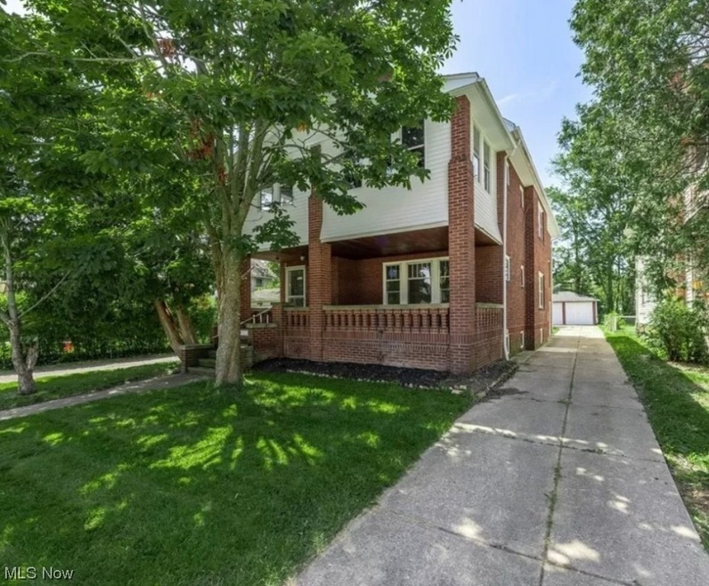 View of side of home featuring a garage and a lawn