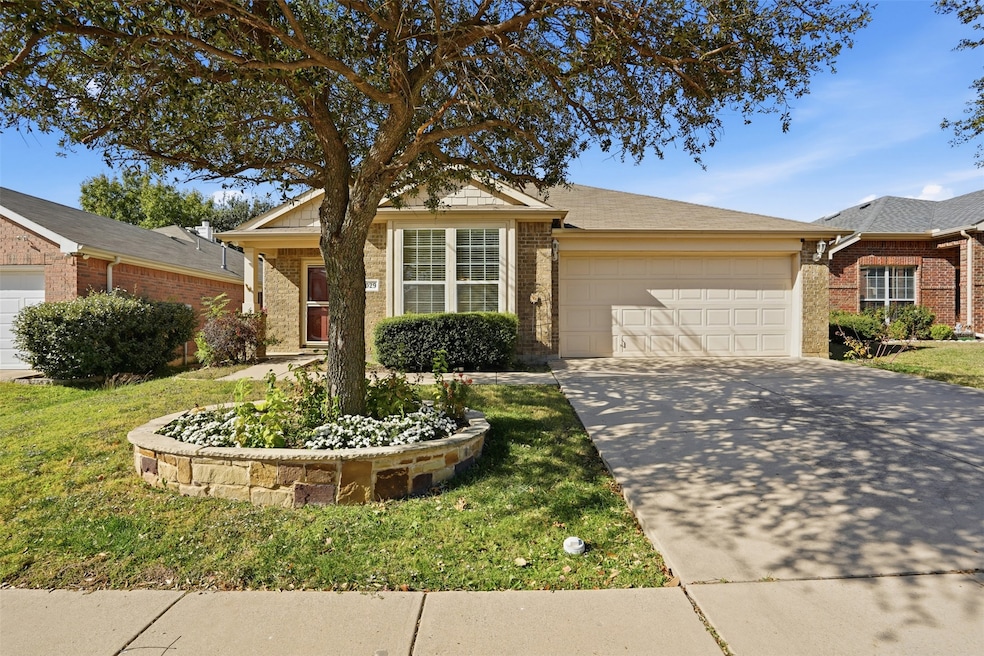 Single story home with concrete driveway, brick siding, an attached garage, and a front yard