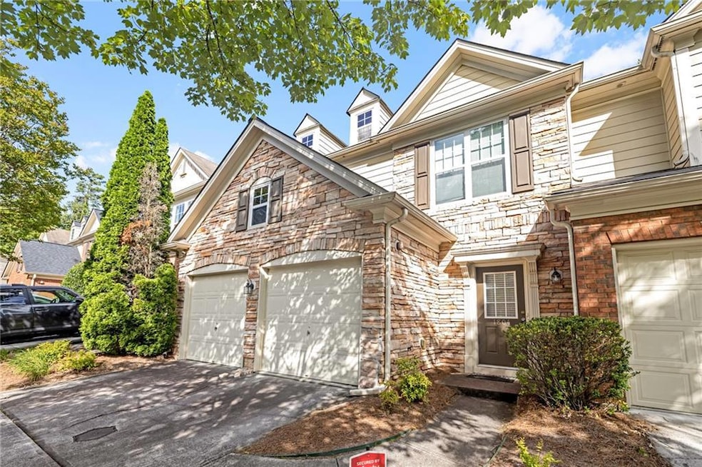 View of front of home with stone siding, driveway, and a garage