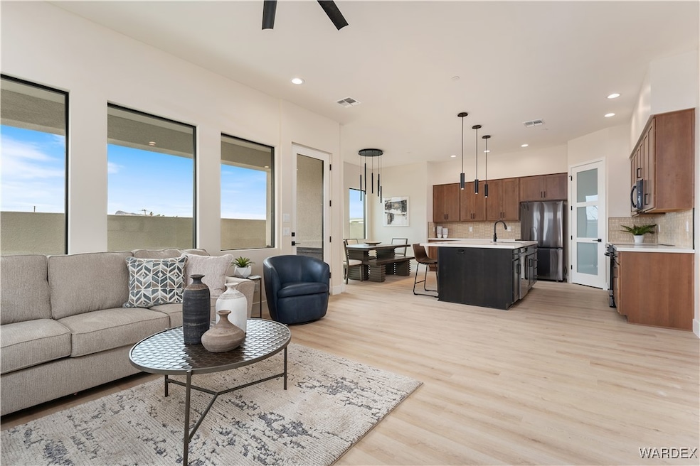Living room with ceiling fan, sink, and light hard