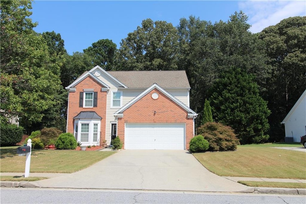Traditional-style home with a front yard, driveway, and brick siding