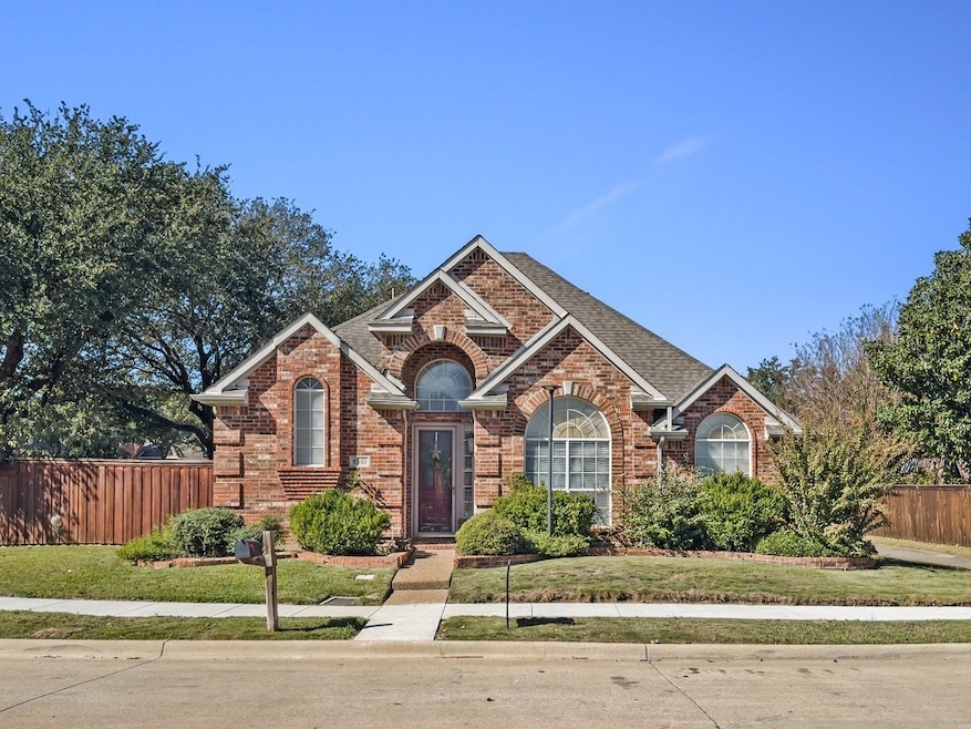 Traditional home featuring brick siding and roof with shingles
