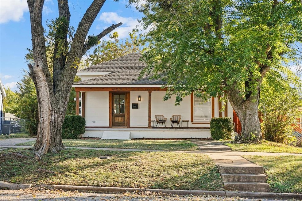 View of front of home with covered porch and roof with shingles