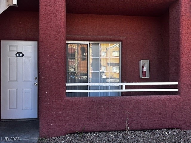 View of exterior entry with stucco siding