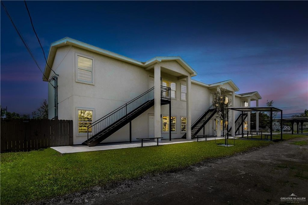 Rear view of house with stairway, stucco siding, and a patio