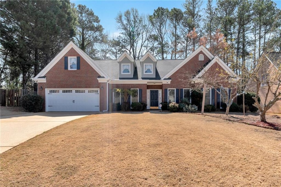 View of front of home featuring fence, a garage, c