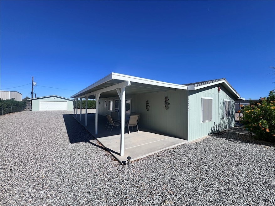 Rear view of house with an outbuilding and a patio area