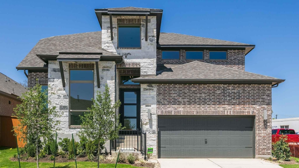 View of front of property with brick siding, driv
