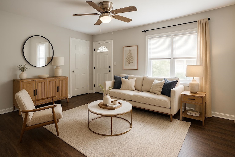 Living area featuring baseboards and dark wood finished floors
