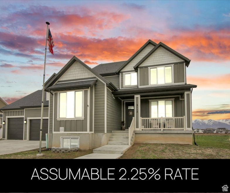 View of front facade featuring board and batten siding, covered porch, concrete driveway, and an attached garage