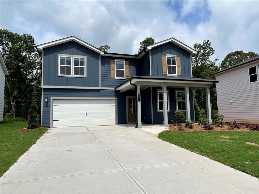 Traditional-style home featuring board and batten siding, a garage, a porch, a front yard, and driveway