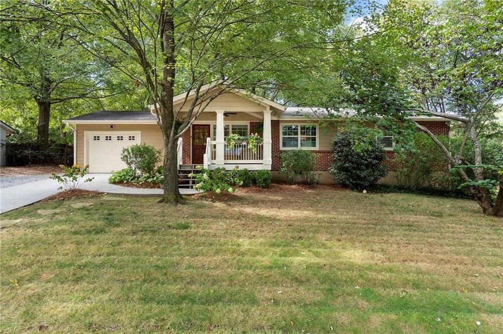Ranch-style house with covered porch, a front lawn, driveway, and brick siding