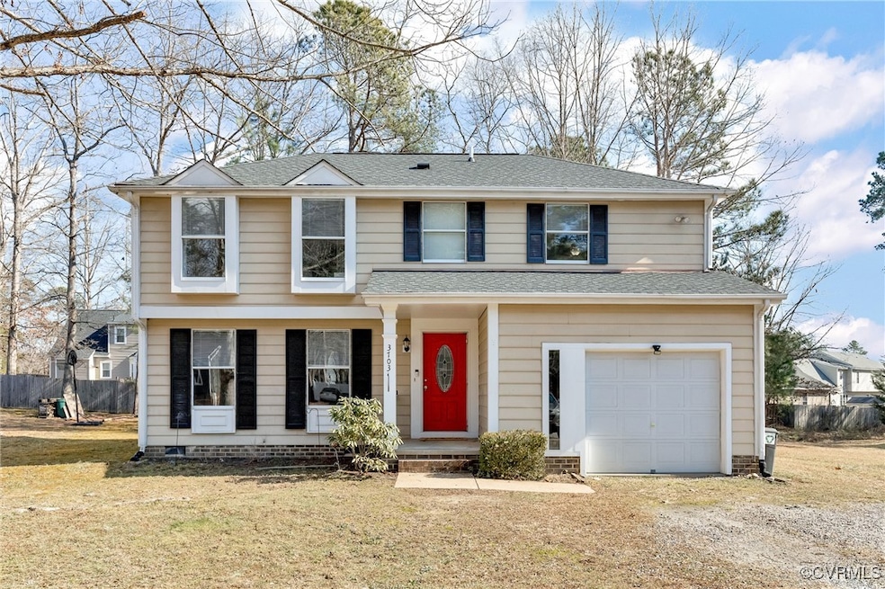Front of property with a garage and a front lawn