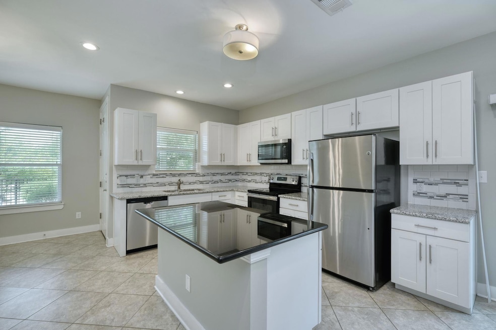Kitchen with white cabinetry, tasteful backsplash