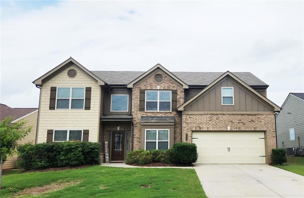 Craftsman-style home with concrete driveway, board and batten siding, a front lawn, and a garage