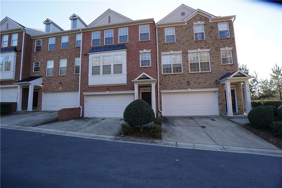View of front facade featuring driveway, brick siding, and a garage
