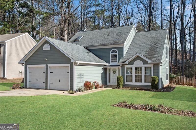 Front of property featuring a front lawn and a gar