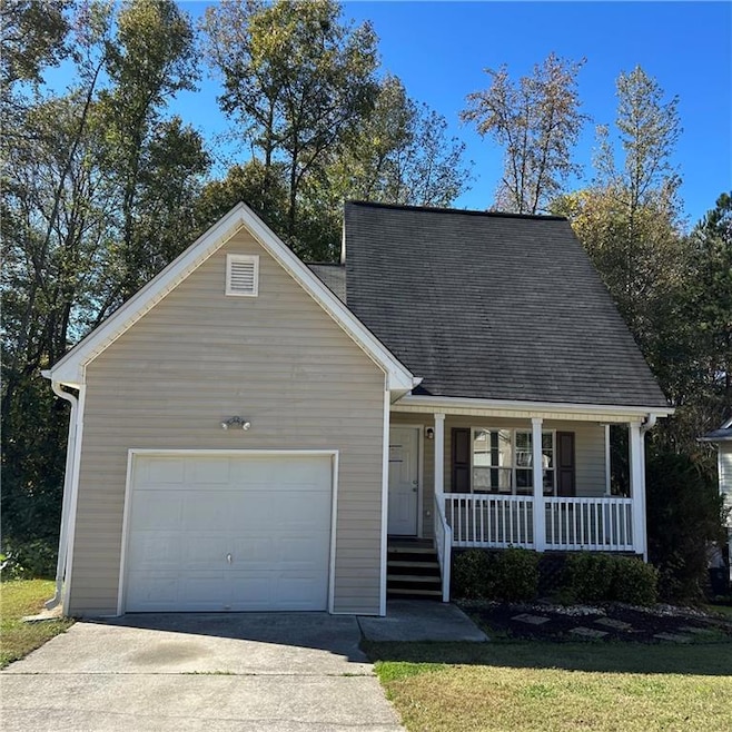 New england style home with covered porch, a garag