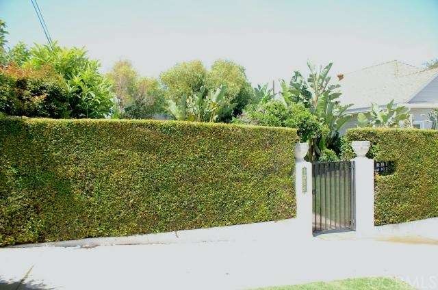 VIEW FROM STREET WITH ENTRY GATE TALL PRIVACY HEDG
